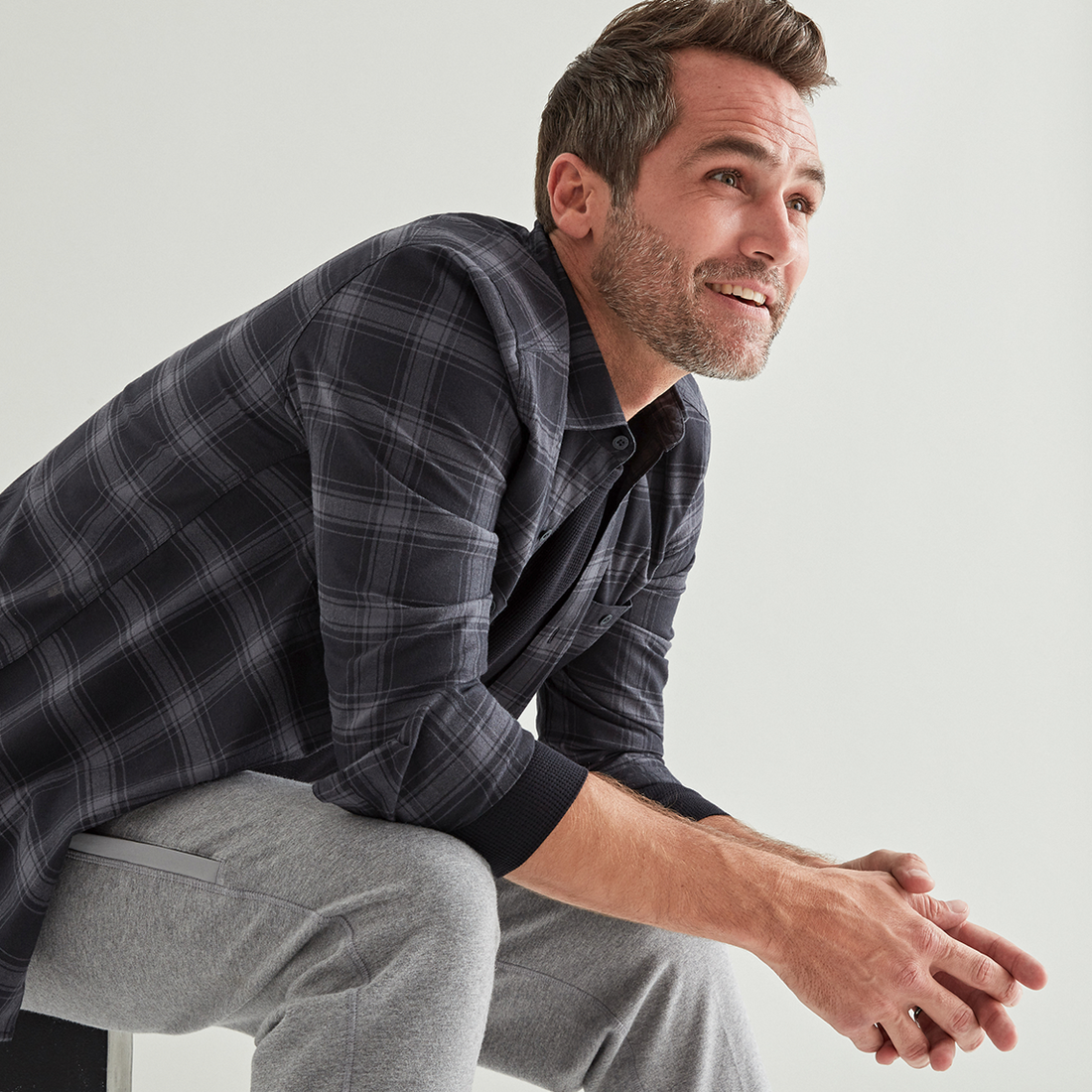 image of a smiling man wearing a WARMKNIT button up and sweatpants