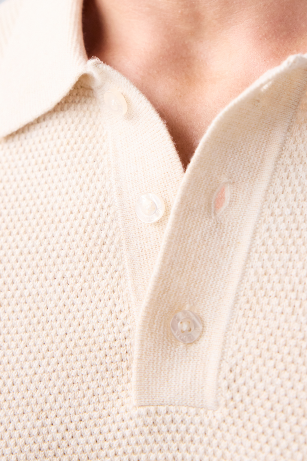 close up image of the collar of a cream tech linen polo